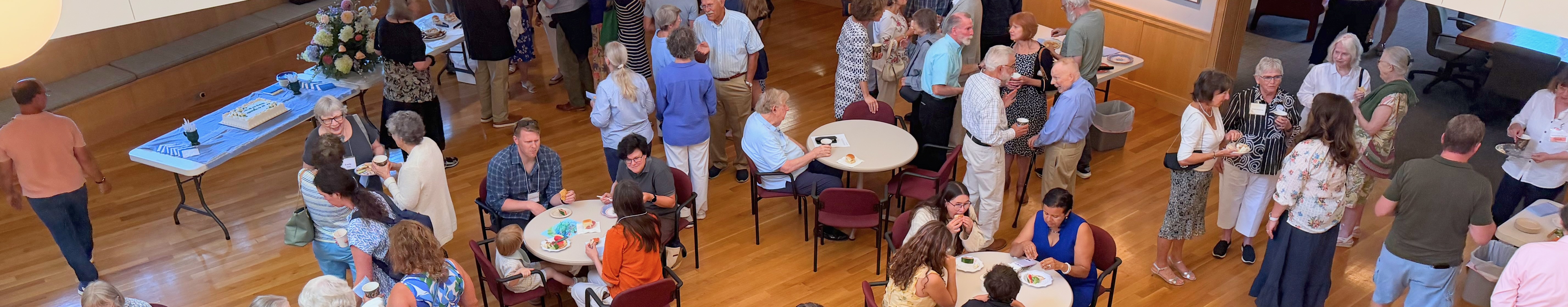 Parishioners gathered in the parish hall during coffee hour, viewed from above