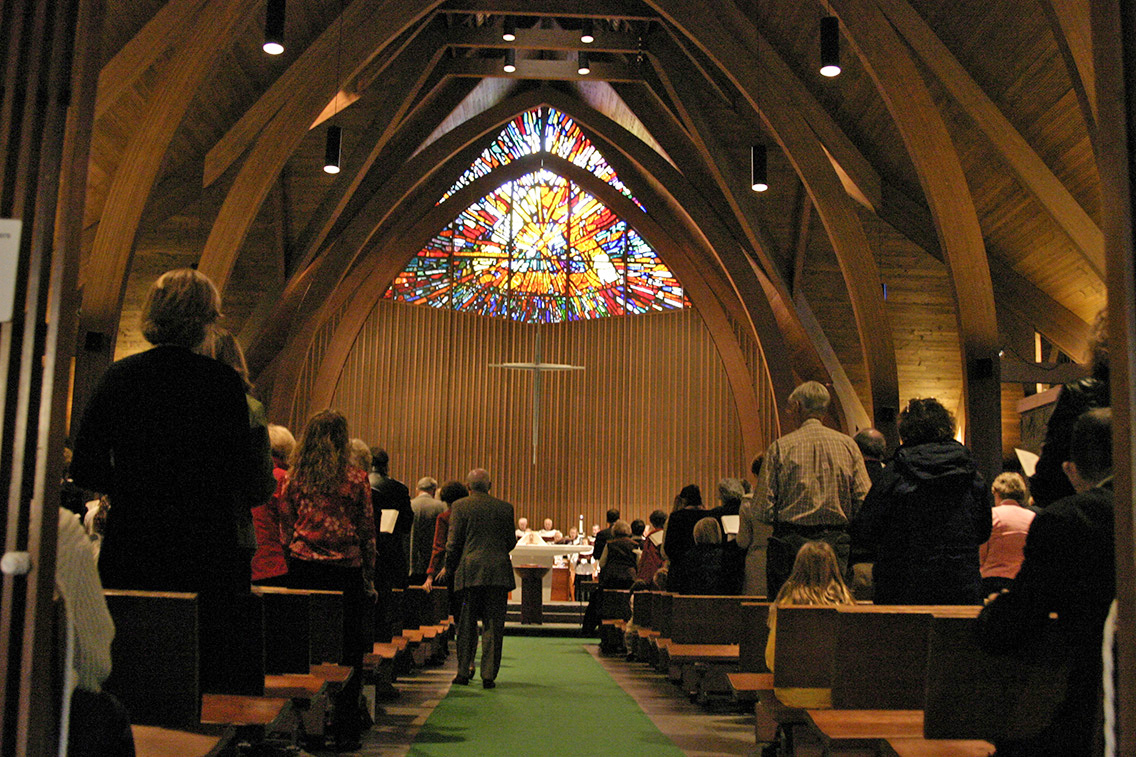 Trinity Episcopal Church sanctuary — congregation in worship with the stained glass window above the altar