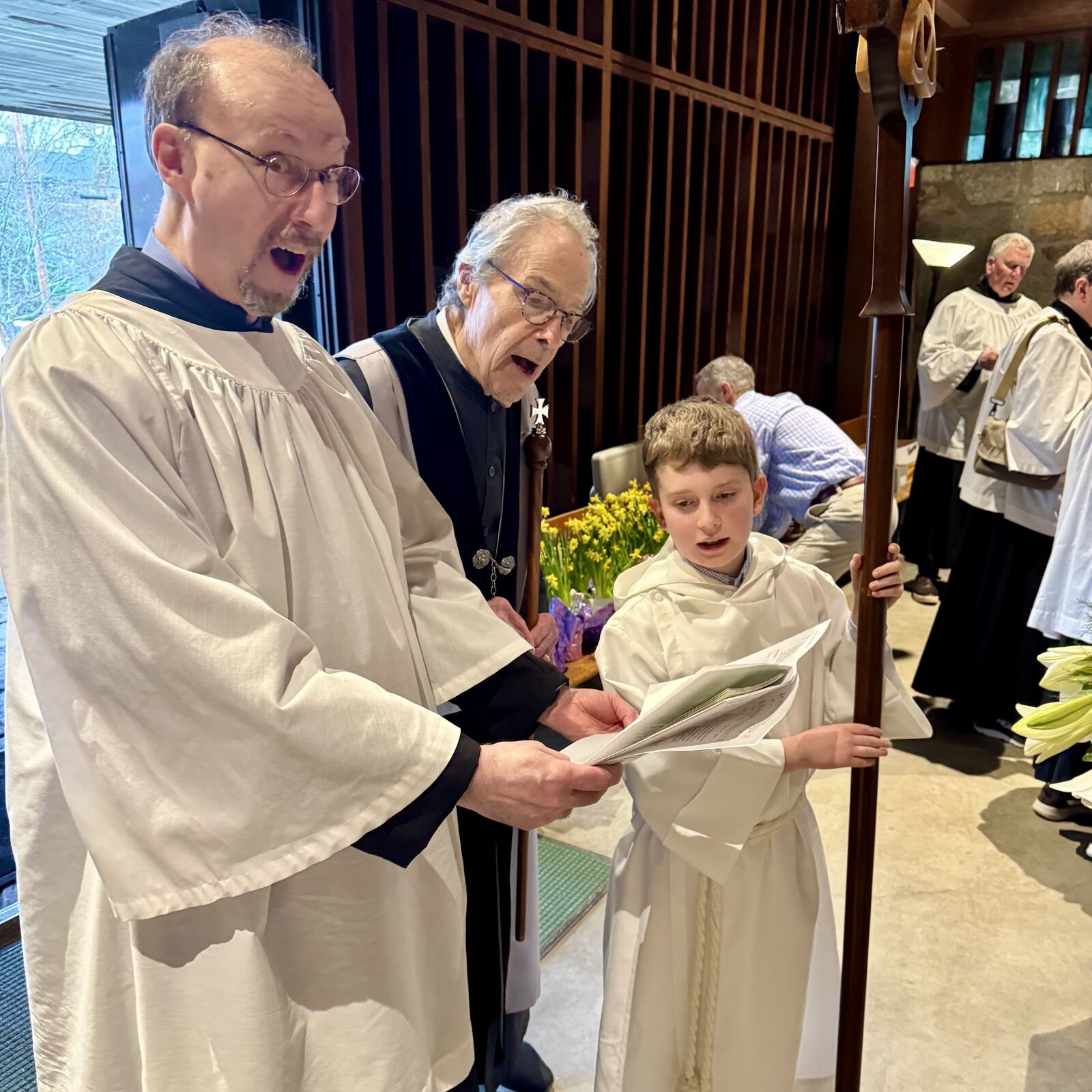 Choir members and a young acolyte sharing a laugh before the service
